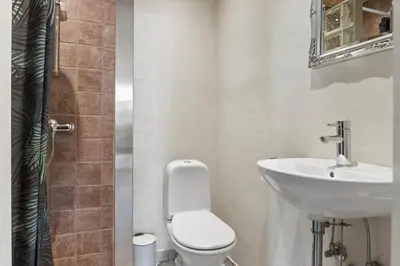 a bathroom with a white toilet and a sink at LK933-Lokken-Olgavej-34 in Løkken