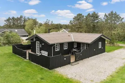 a black house with a black fence around it at LK2029-Lokken-Magdalenevej-55 in Løkken
