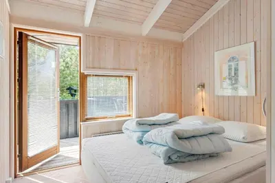 a bedroom with two beds with pillows and a window at LK1840-Lokken-Olgavej-32 in Løkken