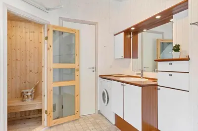 a bathroom with a sink and a washing machine at LK1840-Lokken-Olgavej-32 in Løkken