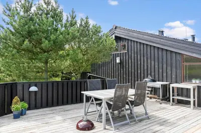 a patio with a table and chairs on a deck at LK1840-Lokken-Olgavej-32 in Løkken