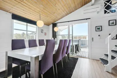 a dining room with a table and purple chairs at LK855-Lokken-Monasvej-7 in Løkken