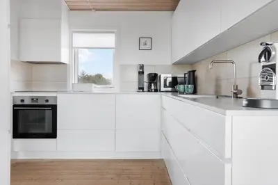 a white kitchen with white cabinets and a window at LK326-Lokken-Monasvej-31 in Løkken