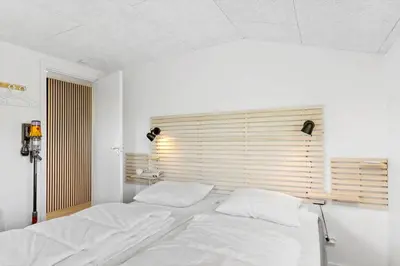 a white bed in a room with a window at BL1440-Blokhus-Moreavej-2 in Blokhus