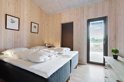 a large bed in a room with wooden walls at BL1557-Saltum-Tolhoj-52 in Saltum