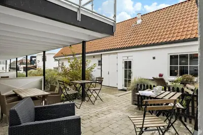 an outdoor patio with tables and chairs and a roof at BL1583-Blokhus-Strandvejen-14-Lejl-12 in Blokhus