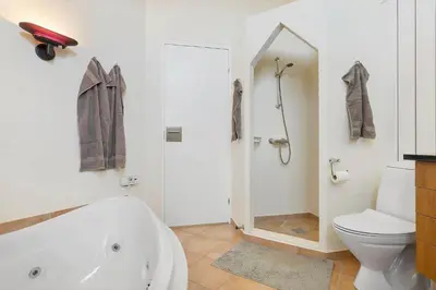 a bathroom with a white tub and a toilet at BL1201-Blokhus-Stromsvej-1 in Blokhus