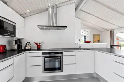 a kitchen with white cabinets and a stove top oven at LK504-Lokken-Kristavej-23 in Løkken