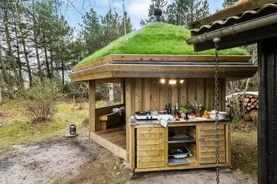 a gazebo with a kitchen with a grassy hill at BL339-Pandrup-Skorr-Karensvej-5 in Pandrup