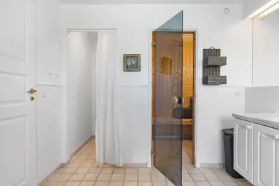 a bathroom with a shower and a white door at BL1478-Blokhus-Ferren-Syd-152 in Blokhus