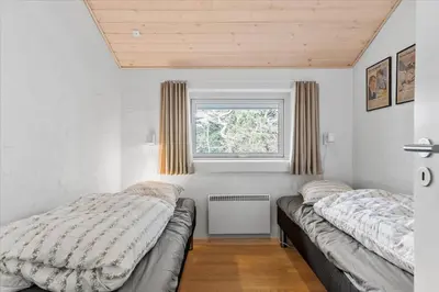 a bedroom with two beds and a window at BL1736-Blokhus-Slettevej-3 in Blokhus