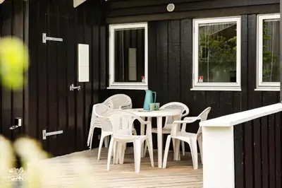a patio with a table and chairs on a house at LK599-Lokken-Stellavej-16 in Løkken