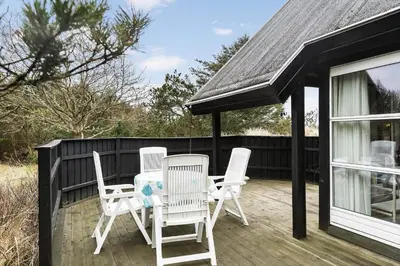 three chairs and a table on a deck at BL1469-Pandrup-Grinden-6 in Pandrup