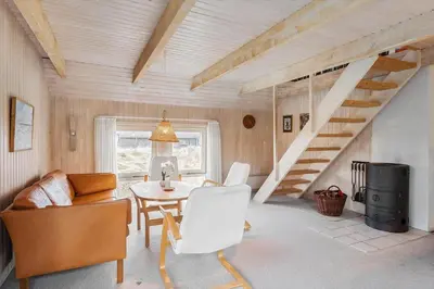 a living room with a table and a staircase at BL1469-Pandrup-Grinden-6 in Pandrup
