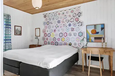 a bedroom with a bed and a table and a wall at BL1679-Blokhus-Gormsvej-33 in Blokhus