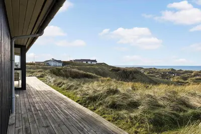 a wooden walkway leading to a house on the beach at LK611-Lokken-Rosavej-9 in Løkken