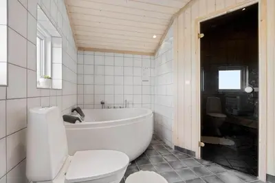 a white bathroom with a tub and a toilet at LK611-Lokken-Rosavej-9 in Løkken