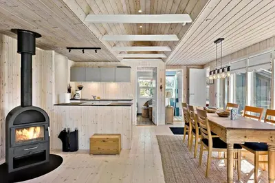 a kitchen and dining room with a wood stove at BL1789-Saltum-Krogsletten-20 in Saltum