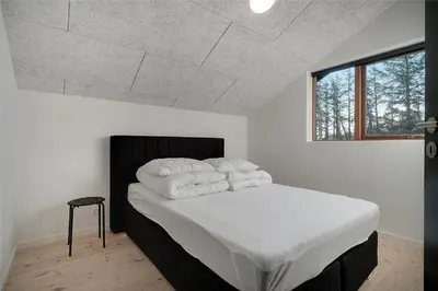 a bedroom with a bed with white sheets and pillows at BL1611-Saltum-Trehoje-3 in Saltum