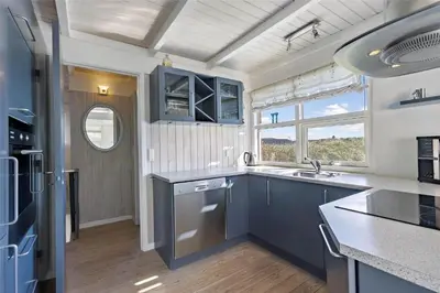 a kitchen with blue cabinets and a sink at BL116-Saltum-Revlingevej-44 in Saltum