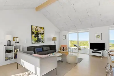 a living room with a couch and a tv at LK553-Lokken-Rosavej-7 in Løkken