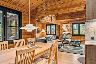 a dining room and living room in a log cabin at BL1224-Saltum-Vikingebanke-7 in Saltum