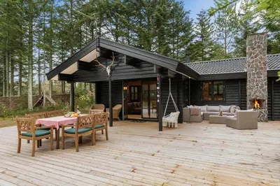 a patio with a table and chairs and a house at BL1224-Saltum-Vikingebanke-7 in Saltum