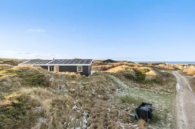 a house sitting on top of a hill next to a road at BL1265-Saltum-Faaborgvej-7 in Saltum