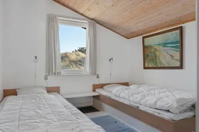 two beds in a room with a window at LK2130-Lokken-Lottesvej-23 in Løkken