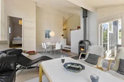 a living room with a fireplace and a table at BL547-Blokhus-Skraavejen-8 in Blokhus