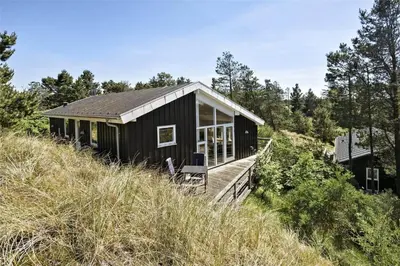 a black house on top of a hill at BL547-Blokhus-Skraavejen-8 in Blokhus