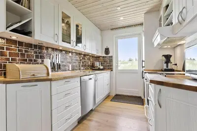 a kitchen with white cabinets and a window at BL1333-Pandrup-Hunetorp-Klitvej-109 in Pandrup