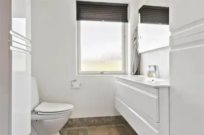 a white bathroom with a toilet and a window at BL1333-Pandrup-Hunetorp-Klitvej-109 in Pandrup