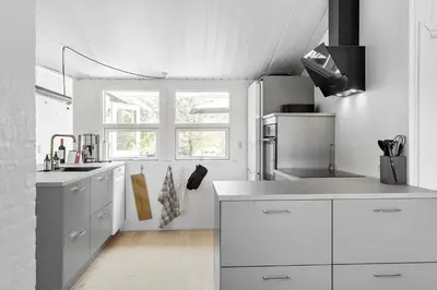 a white kitchen with white cabinets and a window at BL1598-Blokhus-Raevestien-2 in Blokhus