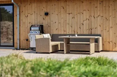 a patio with a table and chairs next to a building at LK2116-Lokken-Marthasvej-5-C in Løkken