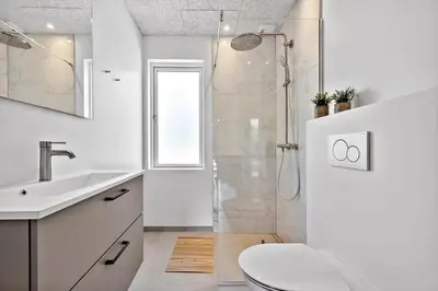 a white bathroom with a shower and a sink at LK2116-Lokken-Marthasvej-5-C in Løkken