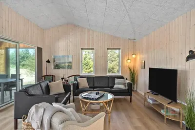 a living room with a couch and a tv at LK2116-Lokken-Marthasvej-5-C in Løkken