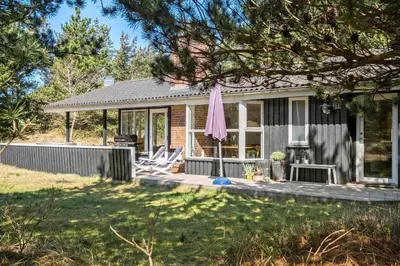 a house with a porch and a pink umbrella at BL1131-Saltum-Daadyrvej-11 in Saltum