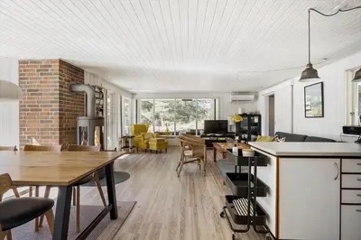 a kitchen and living room with a table and chairs at BL1131-Saltum-Daadyrvej-11 in Saltum