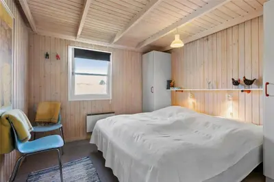 a bedroom with a bed and a chair and a window at BL771-Saltum-Egernvej-36 in Saltum