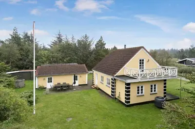 a small yellow house with a large yard at BL367-Pandrup-Rodhus-Kirkevej-5 in Pandrup