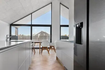 a kitchen with white cabinets and a large window at LK2143-Lokken-Kringelbaekvej-29 in Løkken