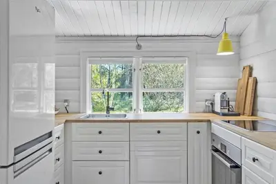 a white kitchen with a sink and a window at BL1363-Blokhus-Fiskene-7 in Blokhus