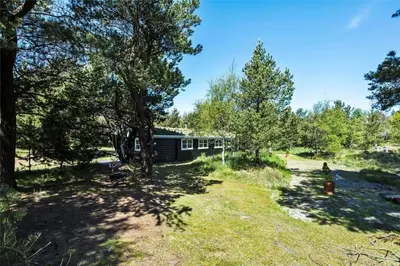 a cabin in the woods with trees at BL1363-Blokhus-Fiskene-7 in Blokhus
