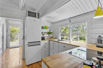 a kitchen with white cabinets and a white refrigerator at BL1363-Blokhus-Fiskene-7 in Blokhus