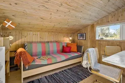 a room with a couch in a tiny house at BL1235-Blokhus-Malinsvej-9 in Blokhus