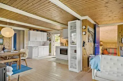 a kitchen and living room with a wooden ceiling at BL1235-Blokhus-Malinsvej-9 in Blokhus