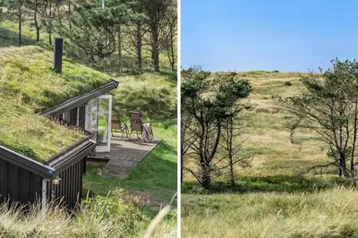 a house with a grassy roof with a bench on a hill at BL1235-Blokhus-Malinsvej-9 in Blokhus