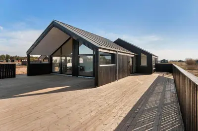 a building with a wooden deck next to a fence at LK2144-Lokken-Kringelbaekvej-31 in Løkken