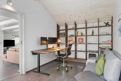 an office with a desk with a computer and a couch at BL1375-Blokhus-Klitvejen-15 in Blokhus
